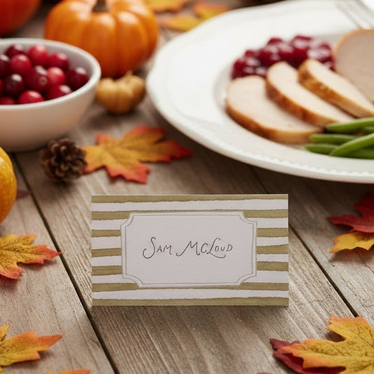 Rectangular place card with green and white striped border on a light gray background