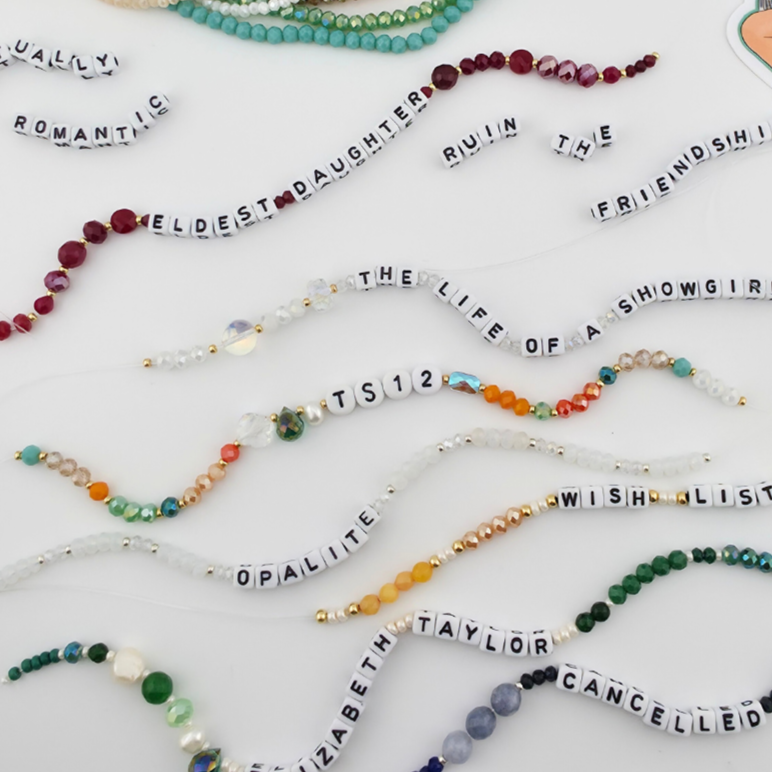 Set of beaded bracelets with various phrases on a white background