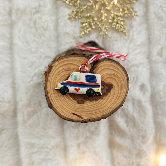 A miniature mail truck ornament on a textured white background